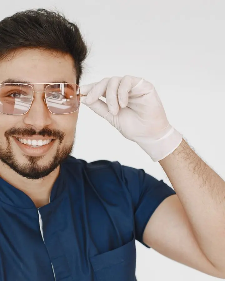 Medic stomatolog ajustându-și ochelarii de protecție